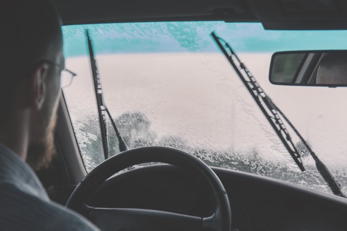 mężczyzna podczas jazdy samochodem w deszczu
